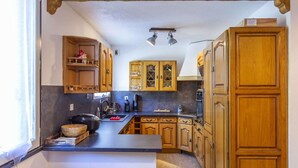 A kitchen with wooden cabinets, a central island, and a window. - Spacious 3-Bedroom Apartment for 8 – Near Ski Slopes in Gourette, Fully Equipped (Gourette)