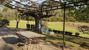 An outdoor patio with a pergola, a table, and chairs. - Camfier self-catering cottage (TOURVES)
