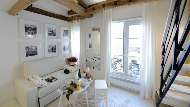 A bright room with a wooden ceiling, white walls, and a balcony with a wrought iron railing. - D4DD Family white (Paris)