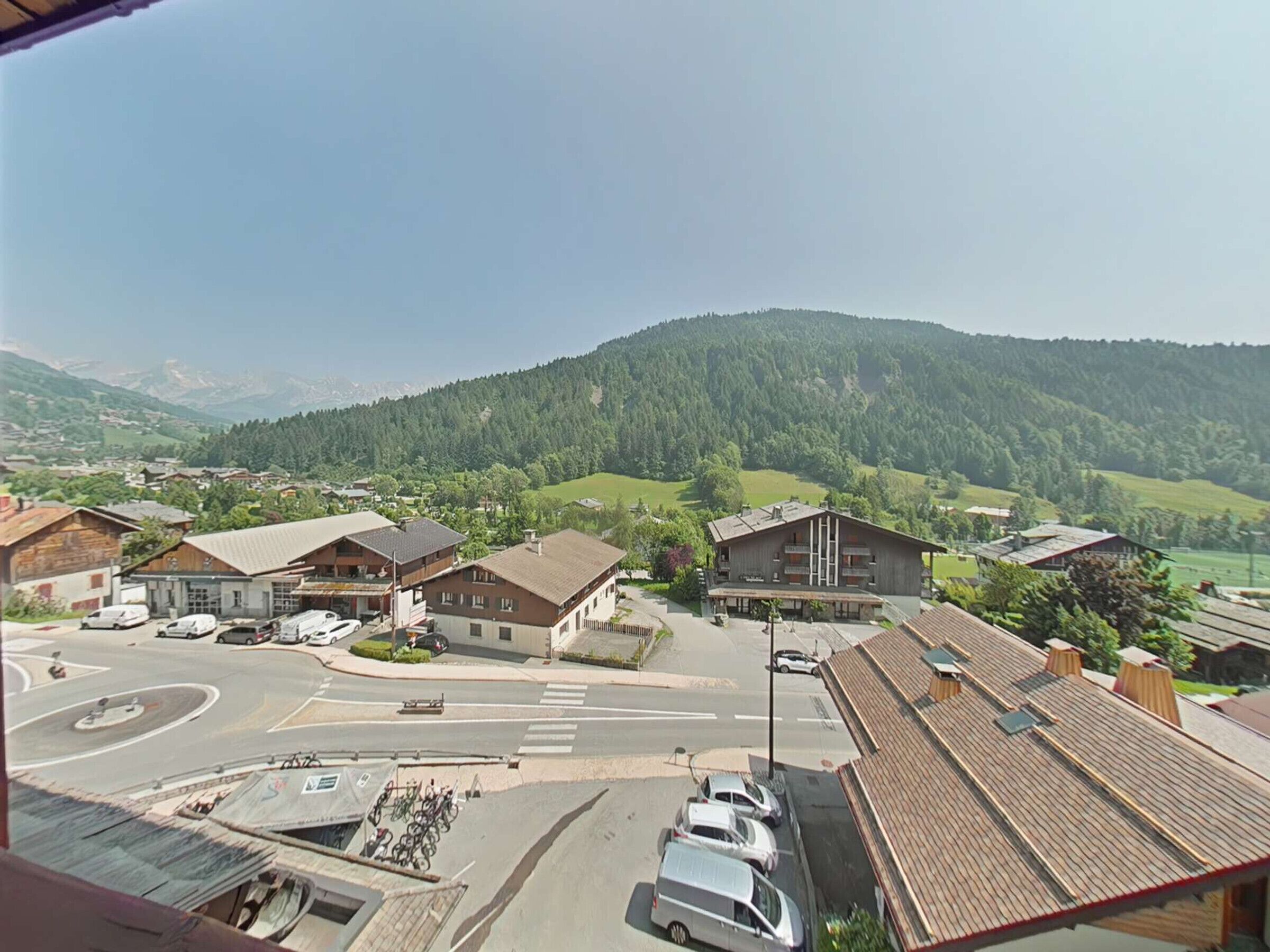 Vista de un pueblo con una montaña al fondo, destacando varias construcciones de arquitectura tradicional.