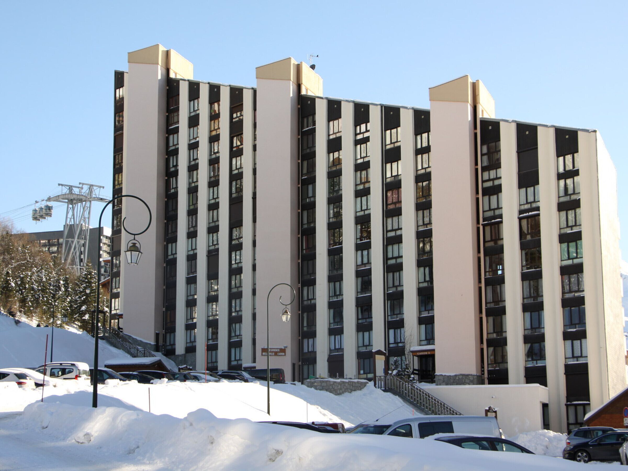 Ein mehrstöckiges Hotel mit modernem architektonischen Design, dessen symmetrische Fassade große Fenster und Balkone aufweist.