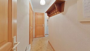 Ein Flur mit Holztüren, einem Heizkörper und einer Deckenleuchte.