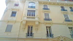 A multi-story building with ornate architectural details, including decorative moldings and balconies with wrought iron railings.