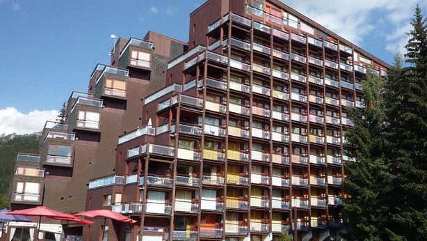 A multi-story hotel with balconies, a pool area with umbrellas, and a view of the mountains. - Ski-in studio, 4 pax, pets allowed - Les Arcs 1800 (Les Arcs 1800)