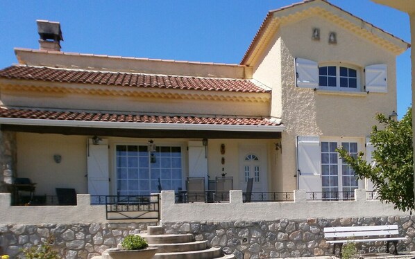 A two-story building with a tiled roof, stone walls, and a balcony with outdoor furniture. - Valerie Talo Mazaugues (MAZAUGUES)