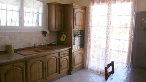 Una cocina con armarios de madera, un lavamanos, una estufa y un refrigerador.