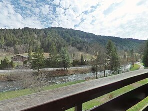 A wooden bridge over a river with a forested mountain in the background. - Cozy 2-room apartment, sleeps 6, pets allowed, ski locker, close to center (Le Grand-Bornand)