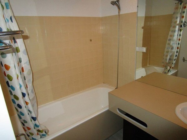 A bathroom with a bathtub, a toilet, and a sink.