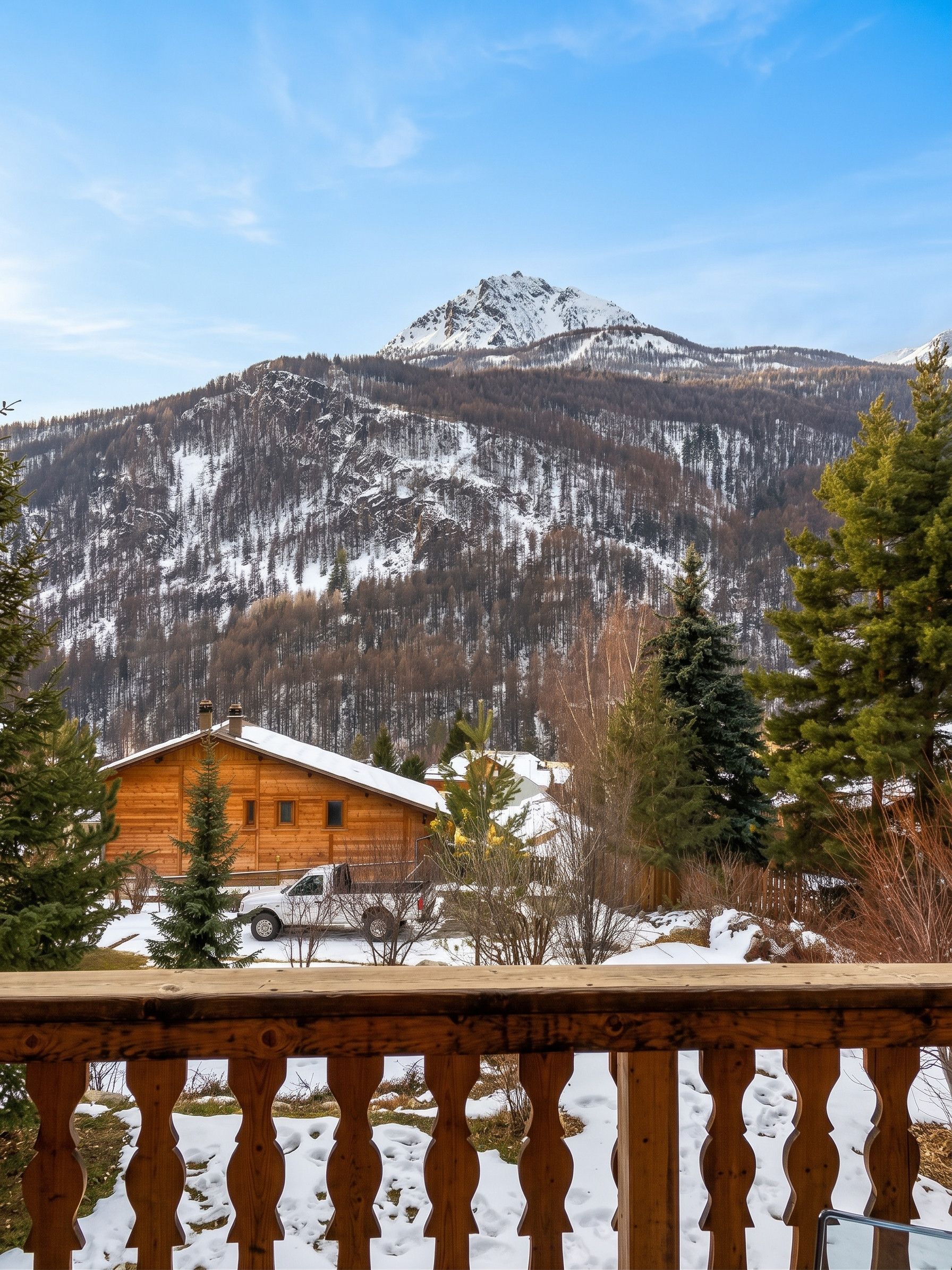 Une cabane en bois offrant une vue sur une chaîne de montagnes enneigées.