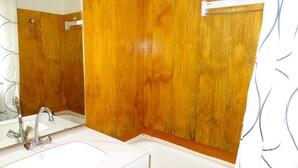 Une salle de bain avec un meuble-lavabo en bois, un lavabo blanc et un miroir.