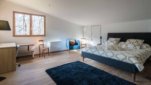 A modern bedroom with a large bed, a desk, and a chair. - Renovated 7-room chalet in Valmorel, 15 people, parking, terrace (Valmorel)