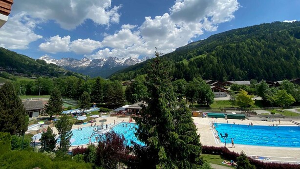 A view of a mountainous landscape with a swimming pool area in the foreground.