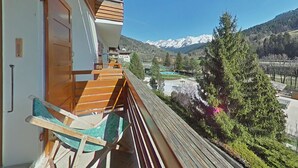 A balcony with wooden railings overlooking a mountainous landscape.
