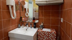 Ein Badezimmer mit Waschbecken, Spiegel, Handtuchhalter und einer kleinen, dekorativen Hasenfigur.