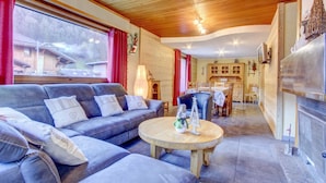 Una sala de estar moderna con un sofá, una mesa redonda de centro y una chimenea.