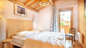 A bedroom with a wooden headboard, a single bed, a small stool, and a chair. - Griotte: Beautiful chalet in the center of Morzine (MORZINE)