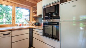 A modern kitchen with a built-in oven, microwave, and refrigerator. - Griotte: Beautiful chalet in the center of Morzine (MORZINE)