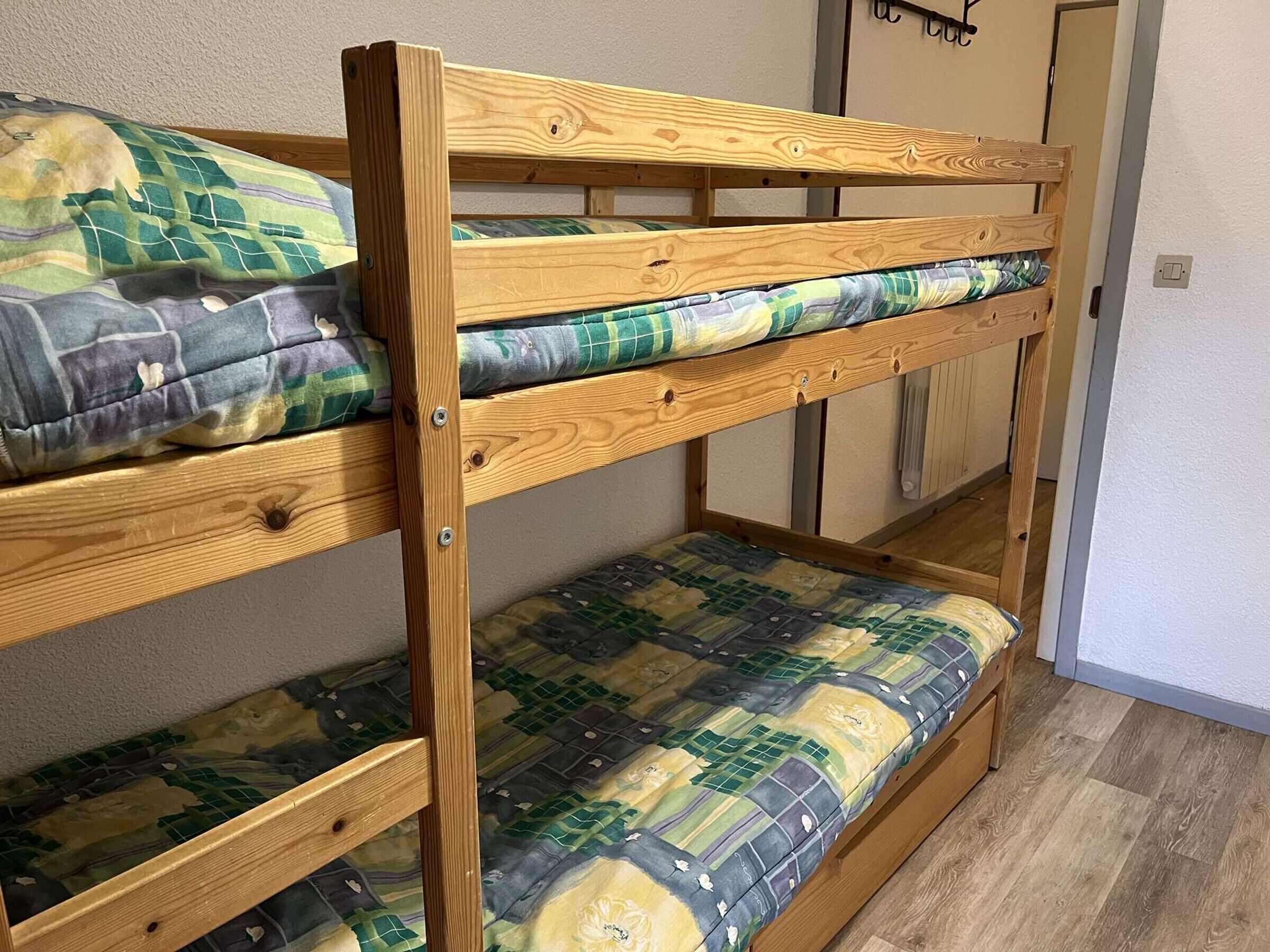 A bunk bed with two levels, each with a mattress and pillow.
