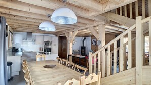 Un intérieur en bois comprenant une cuisine, un coin repas et un escalier.