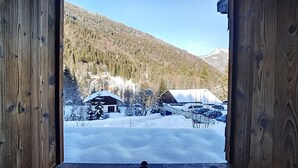 Une cabane en bois, avec un paysage enneigé et une montagne en arrière-plan.