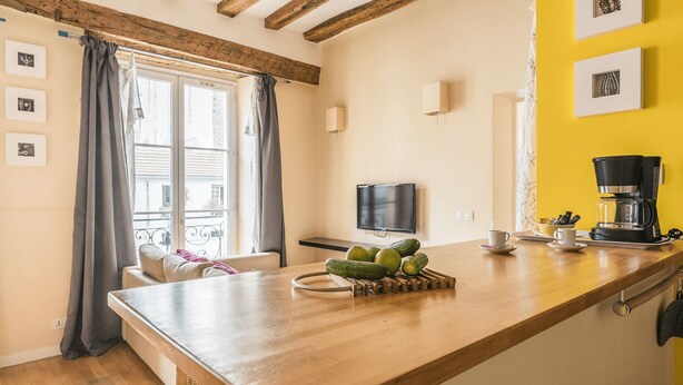A cozy kitchen with a wooden countertop, a TV, and a coffee maker.