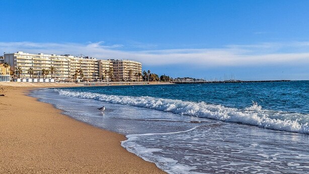 A beachfront hotel with multiple balconies, a sandy beach, and a clear blue sky. - Beachfront 2-Room Apartment with Terrace in Fréjus, Sleeps 4 (Fréjus)