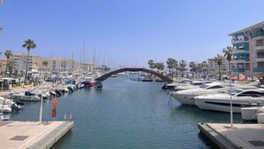 A marina with boats docked, a pedestrian bridge, and buildings in the background. - Beachfront 2-Room Apartment with Terrace in Fréjus, Sleeps 4 (Fréjus)