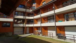 A multi-story building with balconies and a covered outdoor seating area.