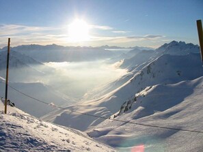 A snow-covered mountain landscape with a clear sky and a visible power line.