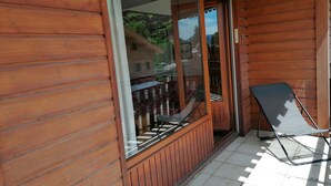 Una cabaña de madera con un portón corredizo de vidrio que da a un balcón.