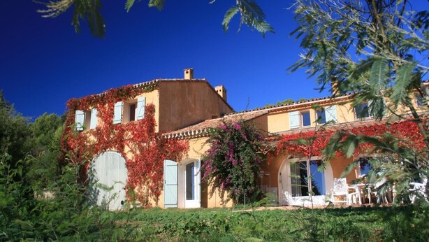 Un bâtiment à deux étages, doté d’un toit plat, de grandes fenêtres et d’un patio couvert.