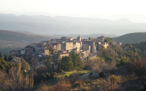 Une ville chargée d’histoire, dotée d’une architecture médiévale et entourée de collines et d’arbres.