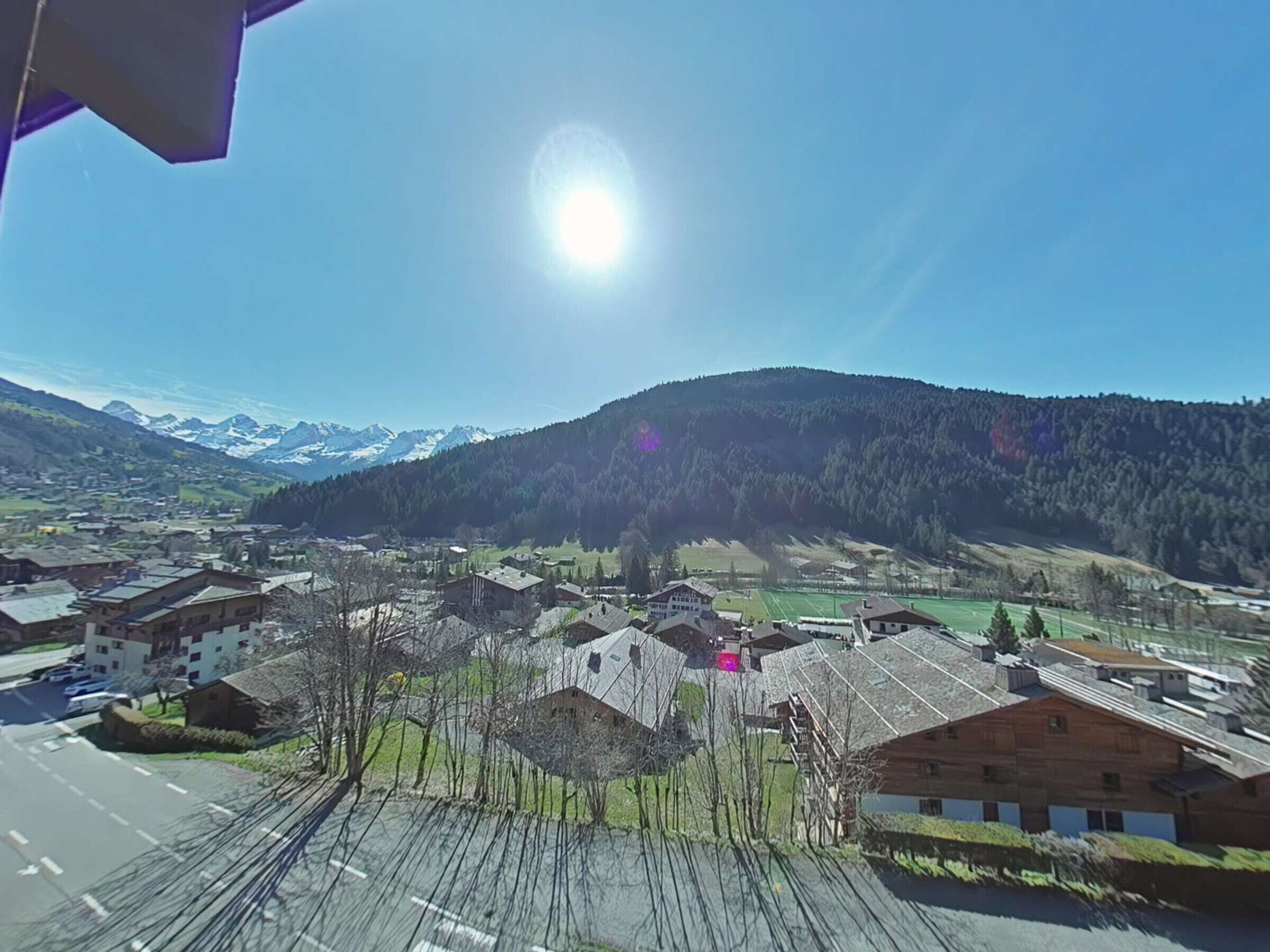 A mountainous landscape with a village, including buildings and a road.