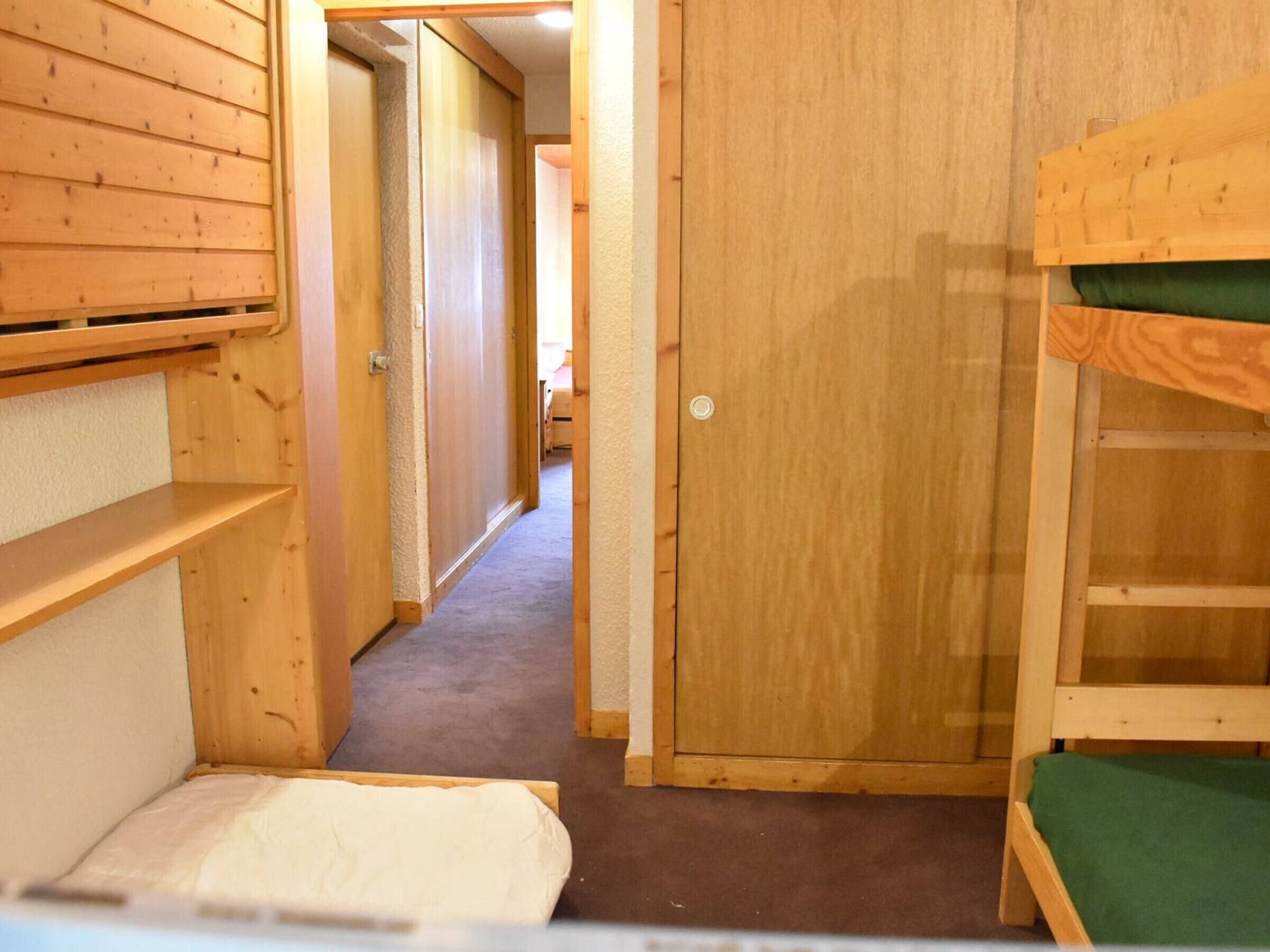 A narrow hallway with wooden walls and a door at the end.