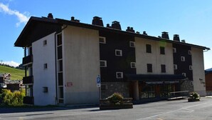 Un hôtel à plusieurs étages avec un parking situé devant.