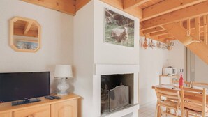 A cozy room with a fireplace, wooden furniture, and a television.
