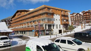 A multi-story hotel with balconies, a ski resort setting, and snow-covered surroundings.