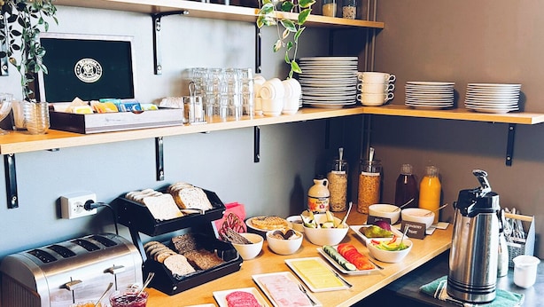 Un bufé de desayuno con diversas opciones de comida, salsas y utensilios.