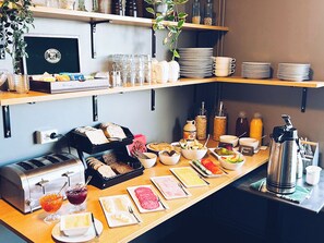 A breakfast buffet with various food items, condiments, and utensils. - Ármót Guesthouse (Rangárþing ytra)