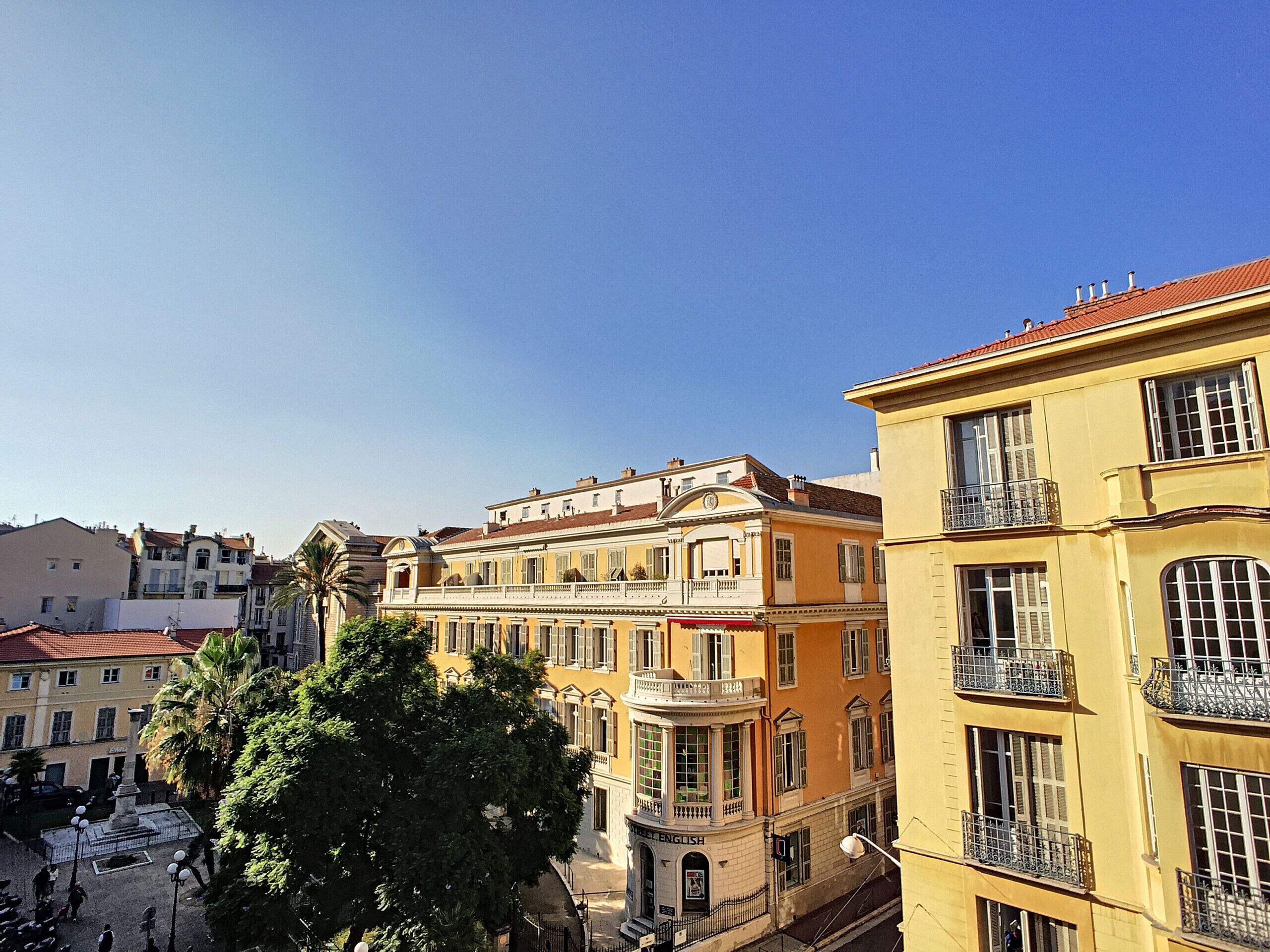 A multi-story building with a yellow facade, large windows, and balconies.