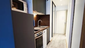 Eine kleine Küche mit Mikrowelle, Spüle und Backofen.