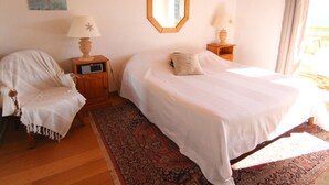 A bedroom with a large bed, two bedside tables with lamps, a chair, a rug, and a painting on the wall. - 3-room apartment, 6 pers, 70m², Vieil Alpe, Alpe d'Huez, pets OK (Huez)