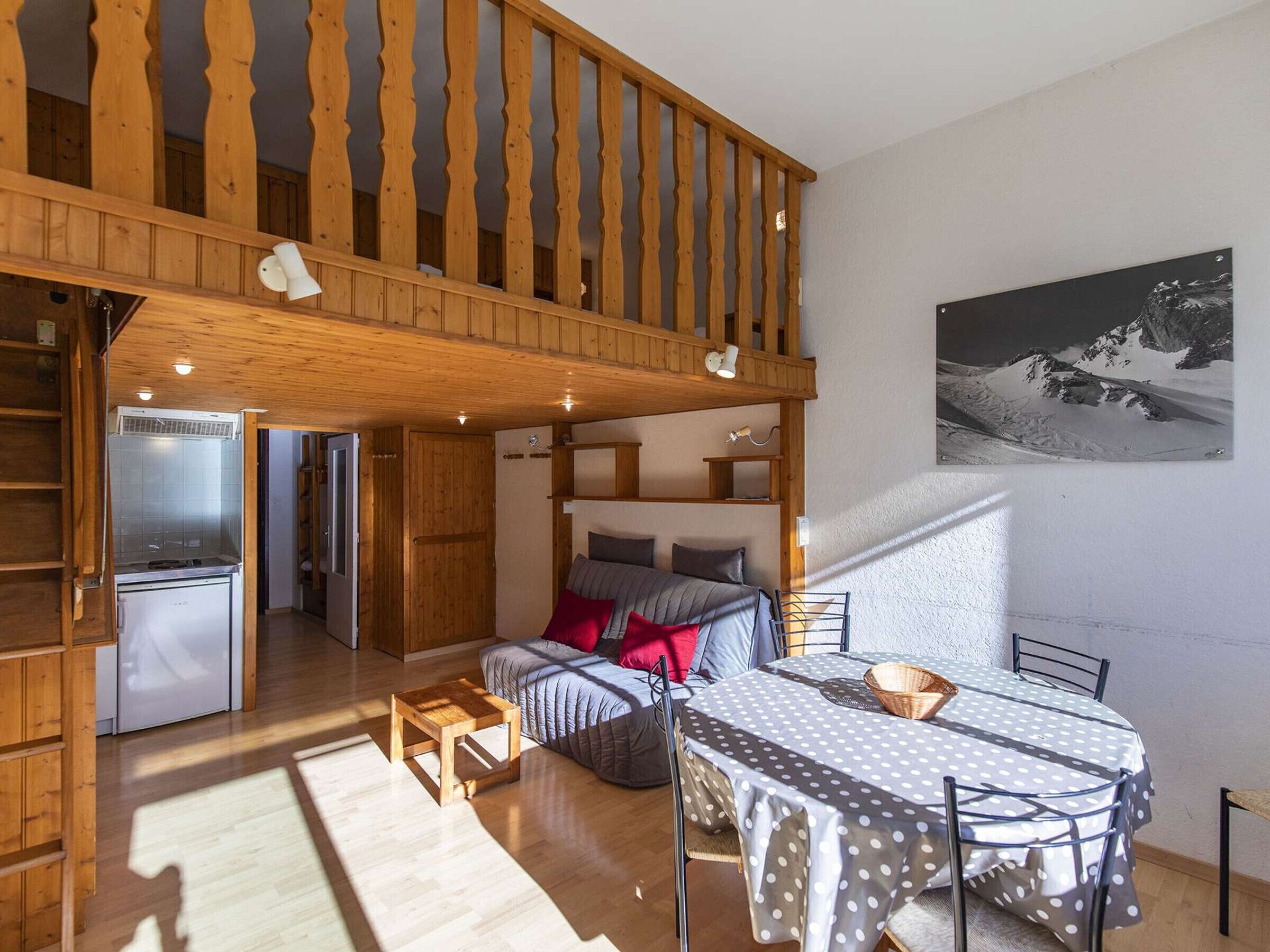 Un chalet confortable comprenant un coin repas, une cuisine et une chambre avec vue sur une montagne enneigée.