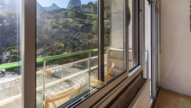 A room with a large window offering a view of a mountainous landscape.