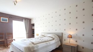 Una camera da letto ordinata con un letto, comodini e una finestra con tende.