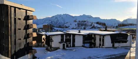 Un bâtiment enneigé, avec une montagne en toile de fond.