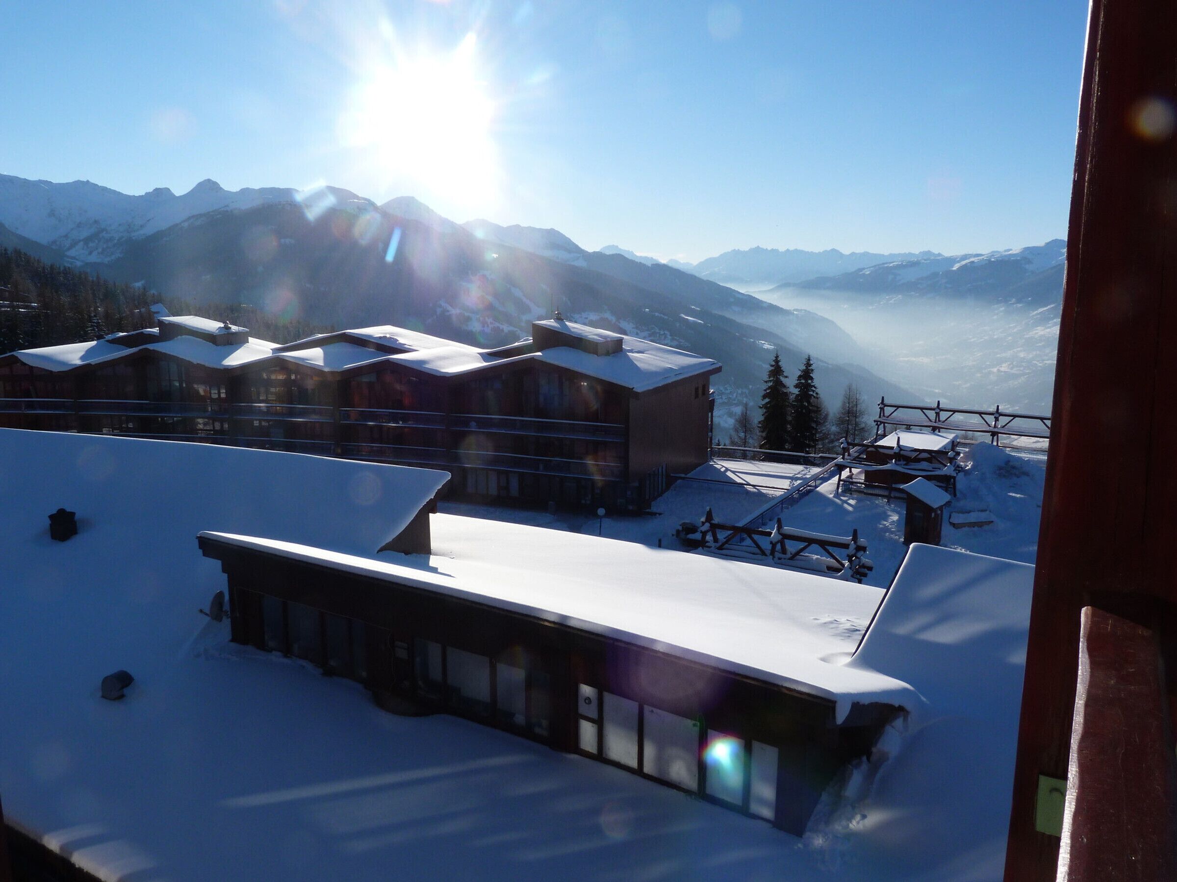 Une station de montagne enneigée, avec des bâtiments et des remontées mécaniques.