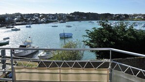 A harbor with boats docked and a town in the background. - Architect-designed house in Ploumanac'h with stunning sea view (Perros-Guirec)