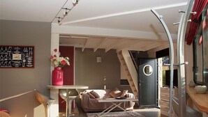 A modern interior with a bed, a dining area, and a staircase leading to an outdoor area. - Architect-designed house in Ploumanac'h with stunning sea view (Perros-Guirec)