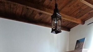 A bedroom with a bed, wooden ceiling, a wooden cabinet, and a hanging light fixture. - Leï Bugadiero - LA CROIX VALMER (La Croix-Valmer)